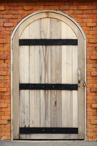Porta de madeira na parede de tijolo — Fotografia de Stock