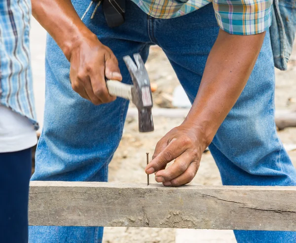 Arbeiter hämmert Nagel in Holz — Stockfoto