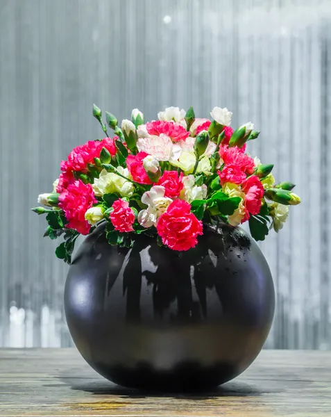 Flores de clavel en maceta de cerámica negra — Foto de Stock