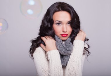 la chica hermosa en un pañuelo y un suéter caliente con labios rojos