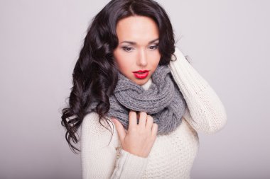 la chica hermosa en un pañuelo y un suéter caliente con labios rojos