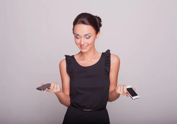 Красива дівчина тримає два телефони — стокове фото