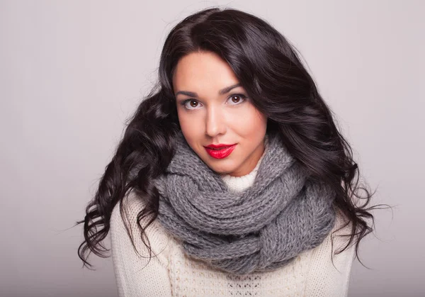 la chica hermosa en un pañuelo y un suéter caliente con labios rojos