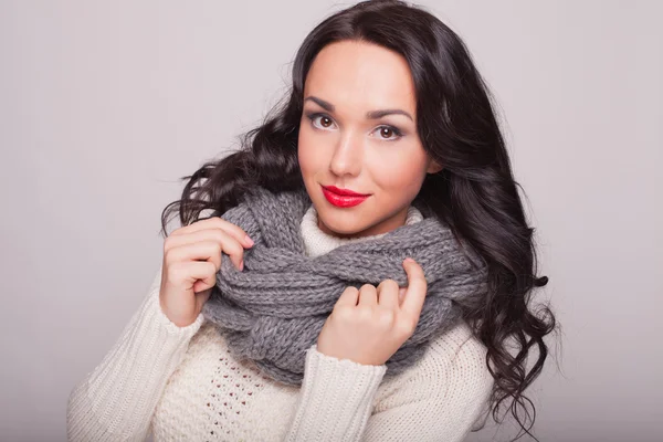 la chica hermosa en un pañuelo y un suéter caliente con labios rojos