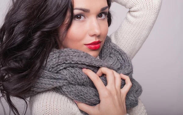 la chica hermosa en un pañuelo y un suéter caliente con labios rojos
