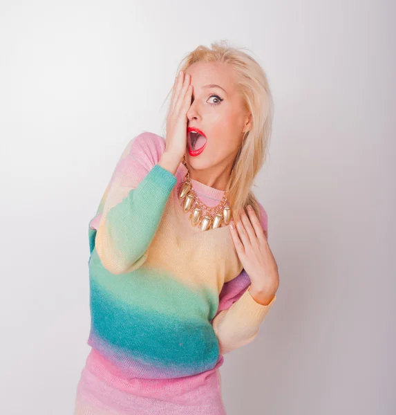 The beautiful fresh blonde the girl in a bright jacket and with red lips on a white background looks in a shot — Stock Photo, Image