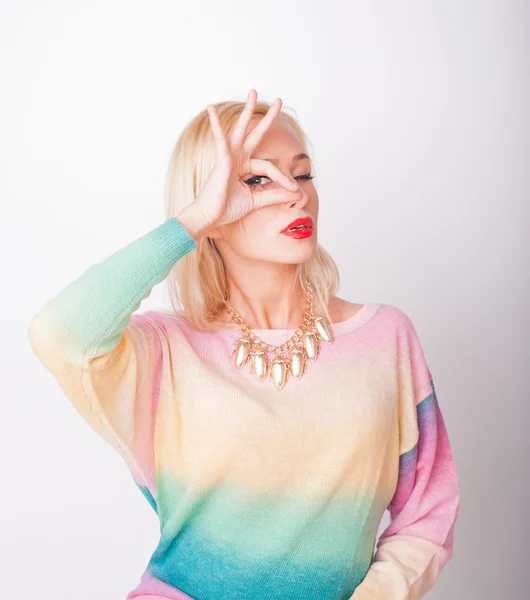 The beautiful fresh blonde the girl in a bright jacket and with red lips on a white background looks in a shot — Stock Photo, Image