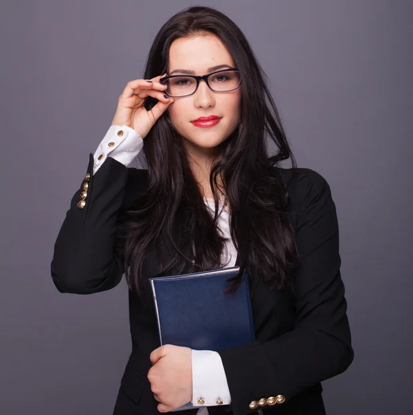 Vacker flicka i glasögon som innehar ett anteckningsblock — Stockfoto