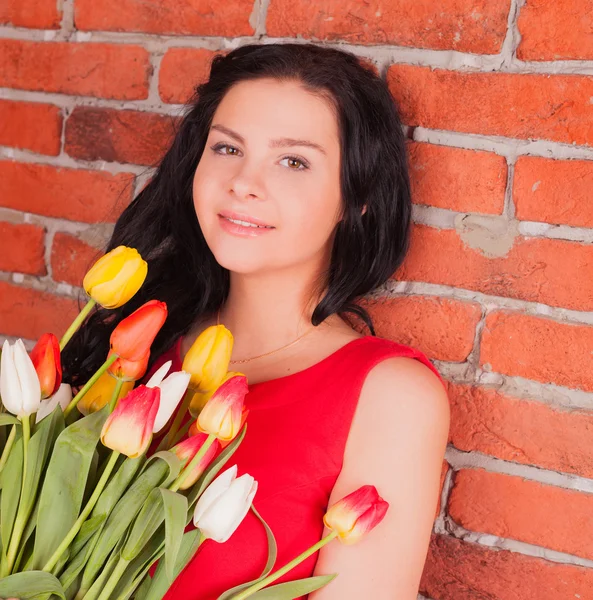 Vacker flicka med blommor tulpaner — Stockfoto