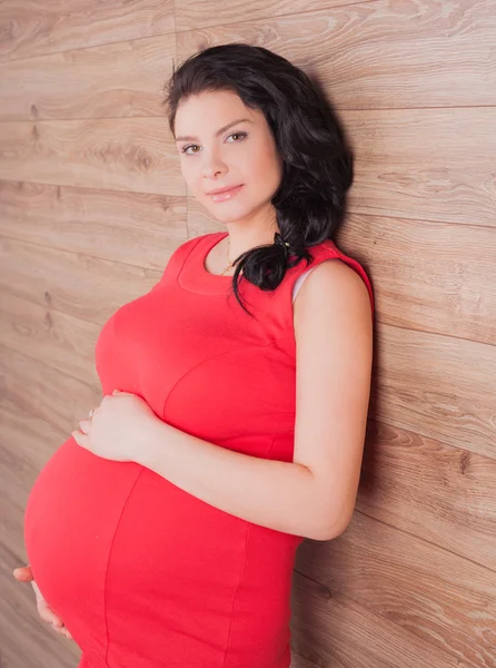 Unga gravida i röd klänning — Stockfoto