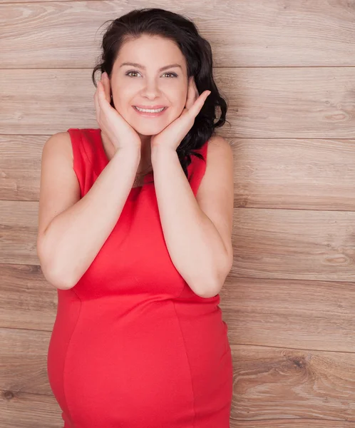 Ragazza incinta in un vestito rosso — Foto Stock