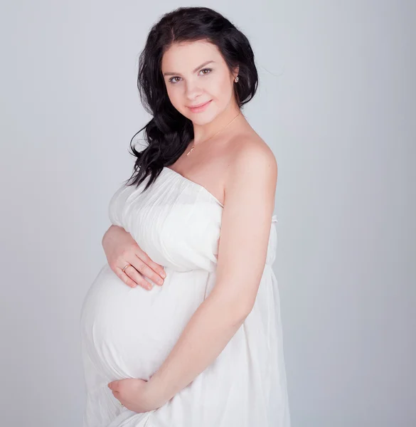 Zwangere vrouw in een witte jurk — Stockfoto