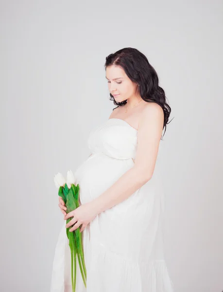 Mulher grávida com tulipas brancas — Fotografia de Stock