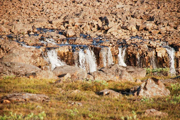 Un paisaje rocoso con una cascada . — Foto de Stock