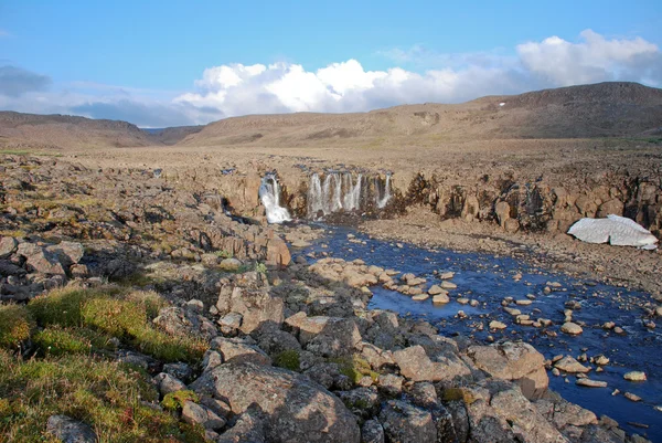 Een rotsachtige landschap met een waterval. — Stockfoto