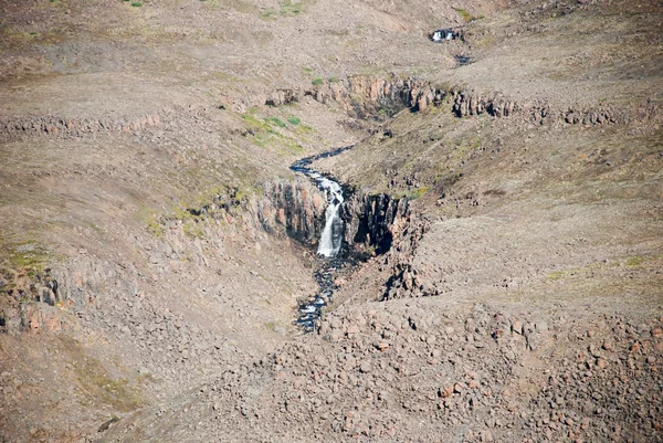 Un paisaje rocoso con una cascada . — Foto de Stock