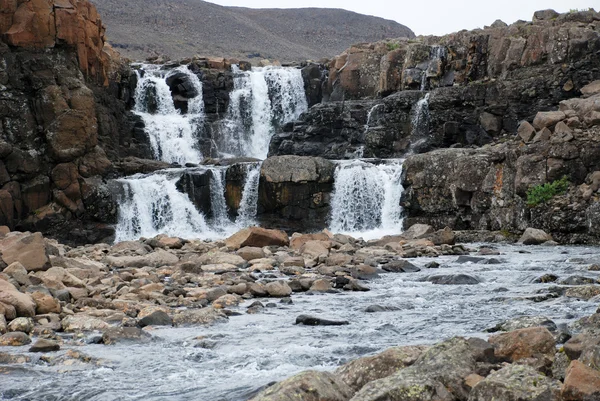 Uma paisagem rochosa com uma cachoeira . — Fotografia de Stock