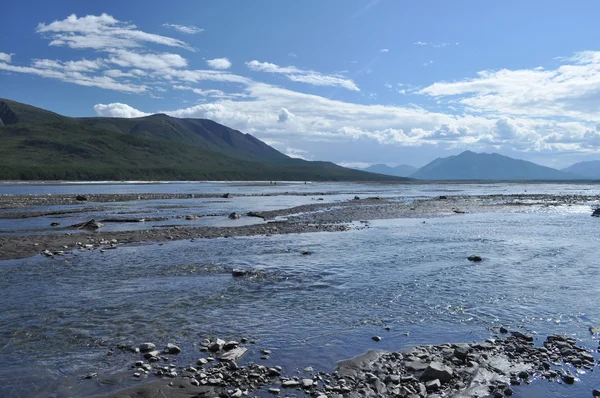 Pebble spottar i flodbädden suntar. — Stockfoto