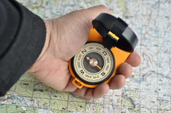 Compass in his hand and a map. — Stock Photo, Image