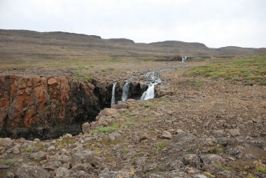 Landscape with rocks and a waterfall.