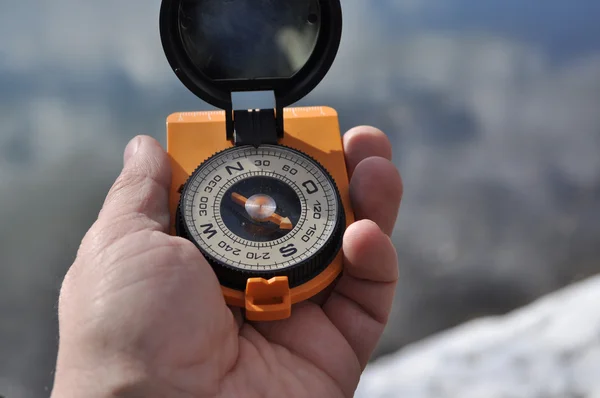 The compass in his hand outdoors. — Stock Photo, Image