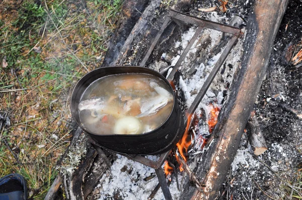 Preparing fish soup on the fire during the trip. — Stock Photo, Image