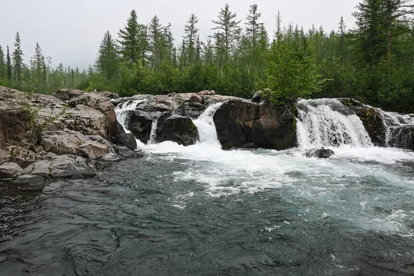 Putorana Plateau, a waterfall on the Grayling Stream. Mountain stream on a  cloudy day Stock Photo - Alamy