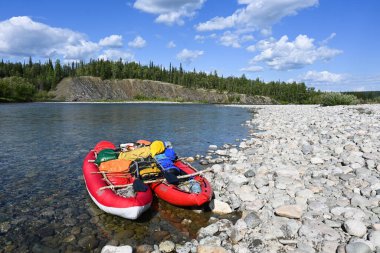 Kuzey Urallar 'da tekne gezisi. Yaz nehri manzarası ve şişme kano..