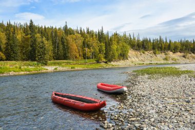 Kuzey Urallar 'da tekne gezisi. Yaz nehri manzarası ve şişme kano..