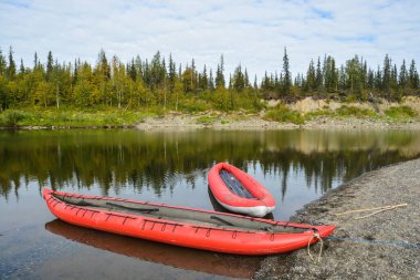 Kuzey Urallar 'da tekne gezisi. Yaz nehri manzarası ve şişme kano..