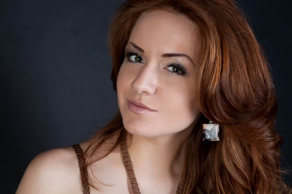 A portrait of beautiful redheaded girl with ear-rings — Stock Photo, Image