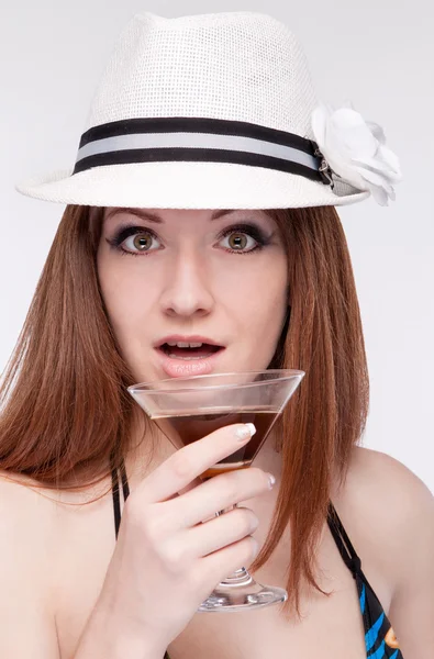 Chica en un sombrero sosteniendo un vaso cerca del labio , —  Fotos de Stock