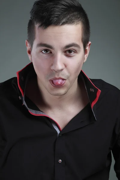 Portrait of a guy who shows tongue — Stock Photo, Image