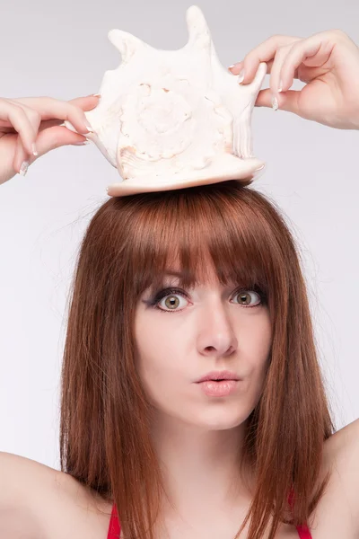 Girl holds a seashell and utterly surprised — Stock Photo, Image