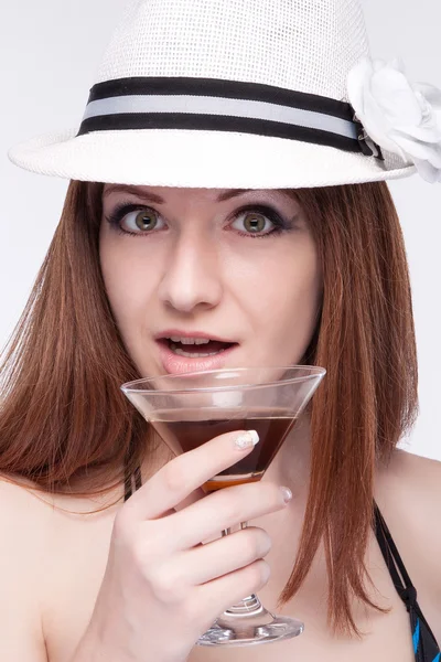 帽子の美しい少女を驚かせたマティーニのグラス — ストック写真
