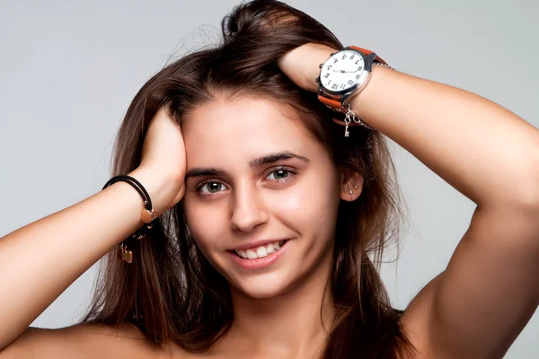 Porträtt av en vacker leende flicka, hålla händerna bakom håret — Stockfoto