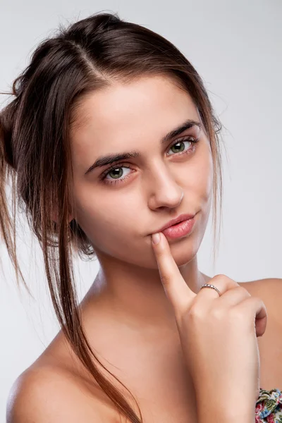 Retrato de uma menina segurando um dedo perto do rosto — Fotografia de Stock