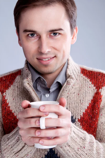 Potrtet Kerl in einem Pullover mit einer Tasse — Stockfoto