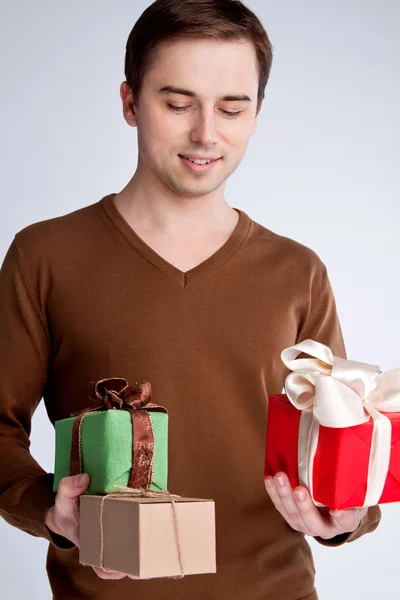 Happy guy holding a lot of gifts — Stock Photo, Image