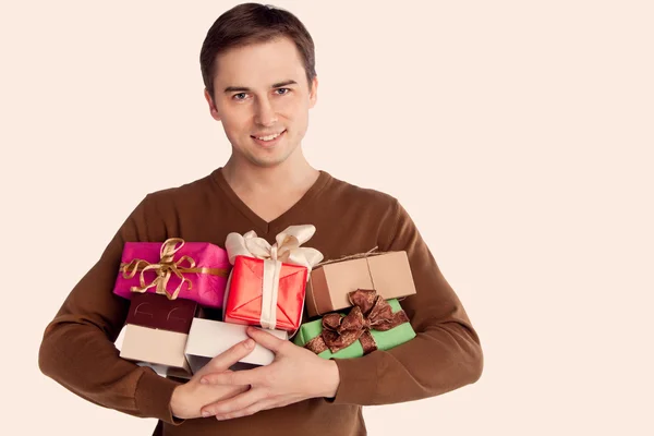 Joven hombre alegre con un montón de regalos (retro ) — Foto de Stock
