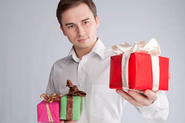 Portrait of a man who holds a gift on his hand in front of him — Stock Photo, Image