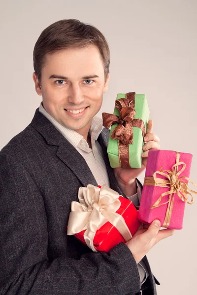 Retrato de un hombre sosteniendo muchos regalos en sus brazos (retro ) — Foto de Stock