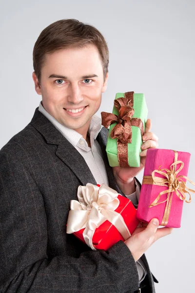 Retrato de un hombre sosteniendo muchos regalos en sus brazos — Foto de Stock