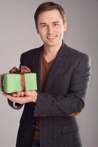 Portrait of a smiling man offers a gift (retro) — Stock Photo, Image