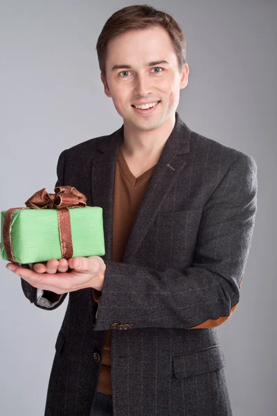 Retrato de un hombre sonriente ofrece un regalo —  Fotos de Stock