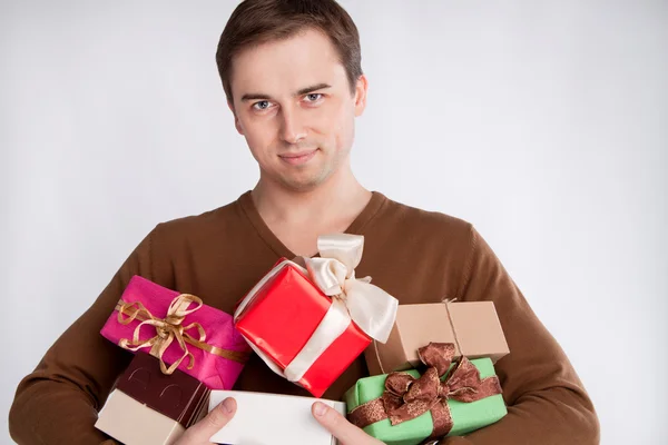Gülümseyen adam elinde bir sürü hediyeler — Stok fotoğraf