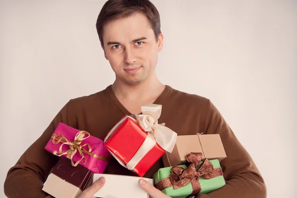 Smiling man holding a lot of gifts (retro) — Stock Photo, Image