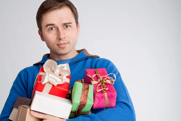 Porträt eines überraschten Mannes mit Geschenken — Stockfoto