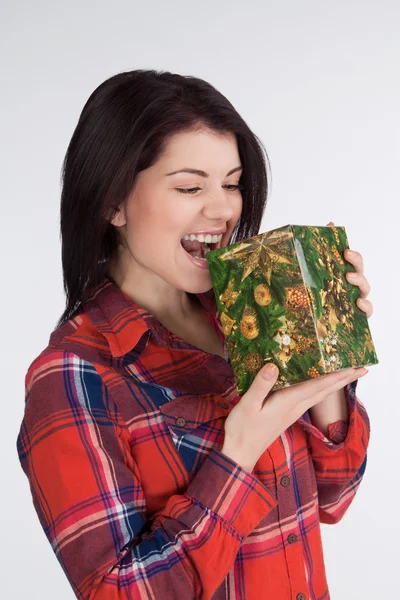 Girl in a plaid shirt bite gift — Stock Photo, Image