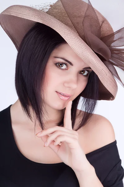 Retrato de una chica en un sombrero con el dedo en los labios — Foto de Stock